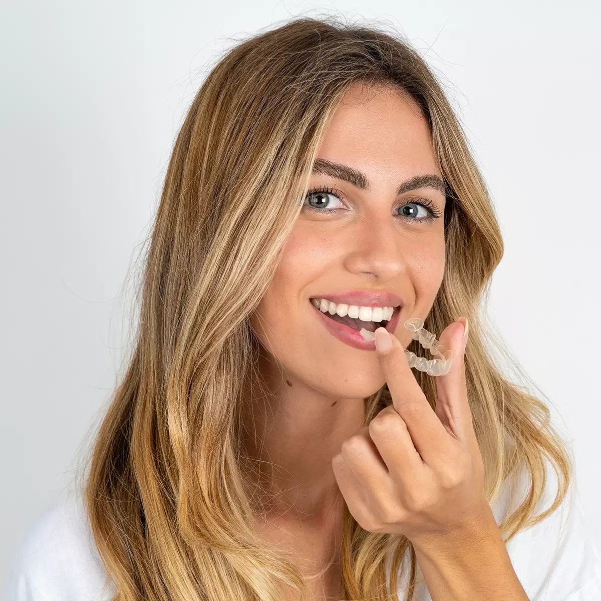 Pretty Girl Holding Invisalign Tray Smiling